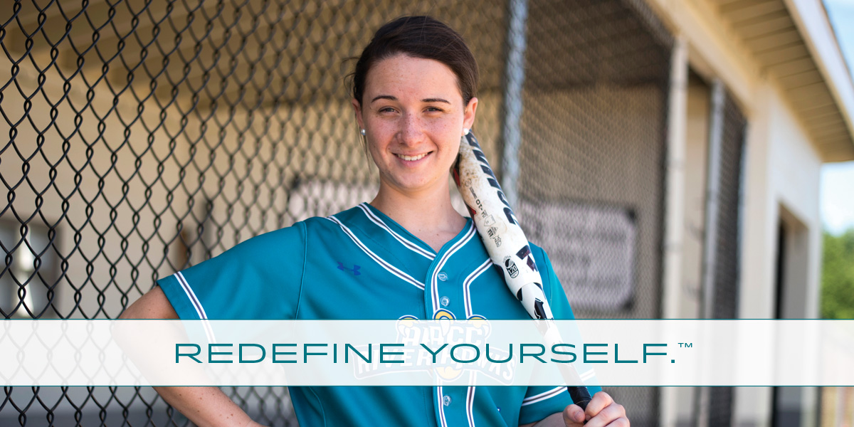 Redefine Michelle standing with softball bat over her shoulder.