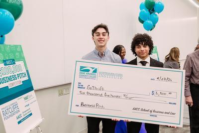 Go Thrift owners holding a giant check.
