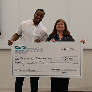 Grandma's Southern Pies pitcher holding a large check with Stephanie Goldenberg