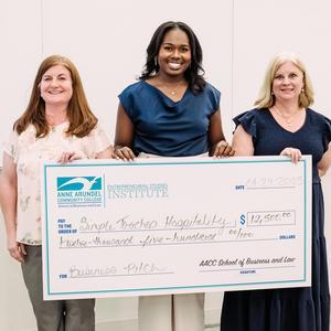 A student poses for a photo with a check and Business and Law Assistant Dean and ESI professor Stephanie Goldenberg.