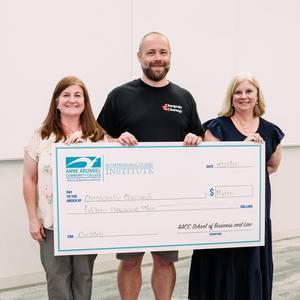 A student poses for a photo with a check and Business and Law Assistant Dean and ESI professor Stephanie Goldenberg.