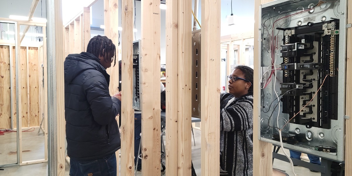 Two students working on electrical panels