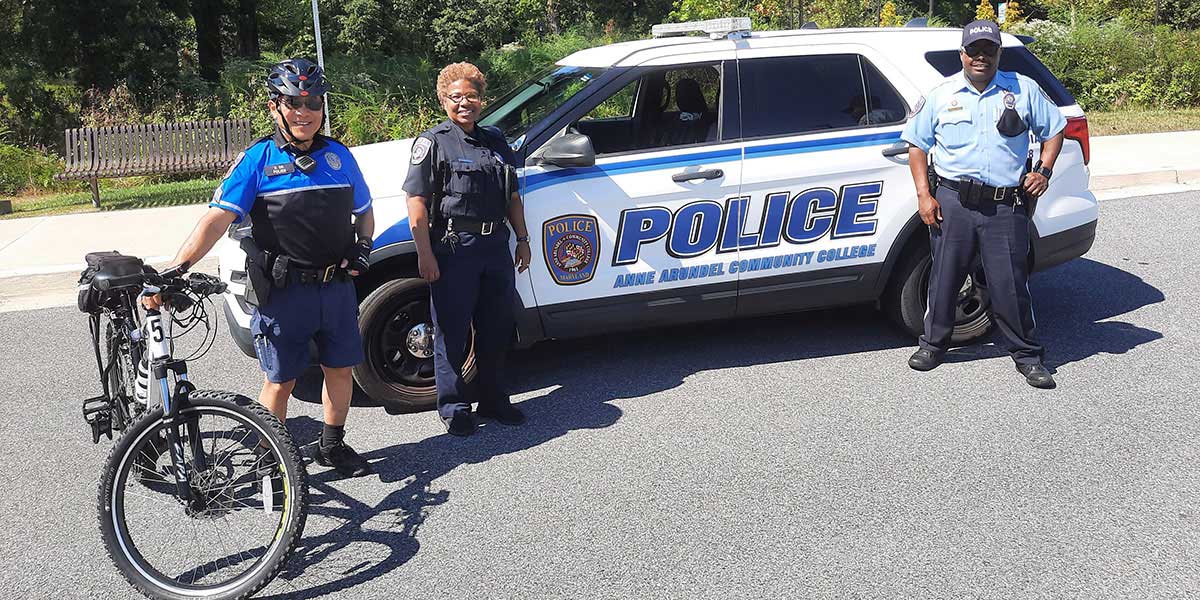 Various Public Safety officers standing in front of patrol car