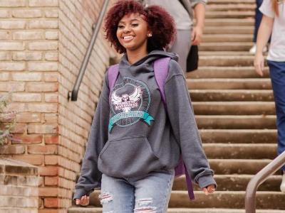 Young student walking down stairs at the AACC Arnold campus with backpack.