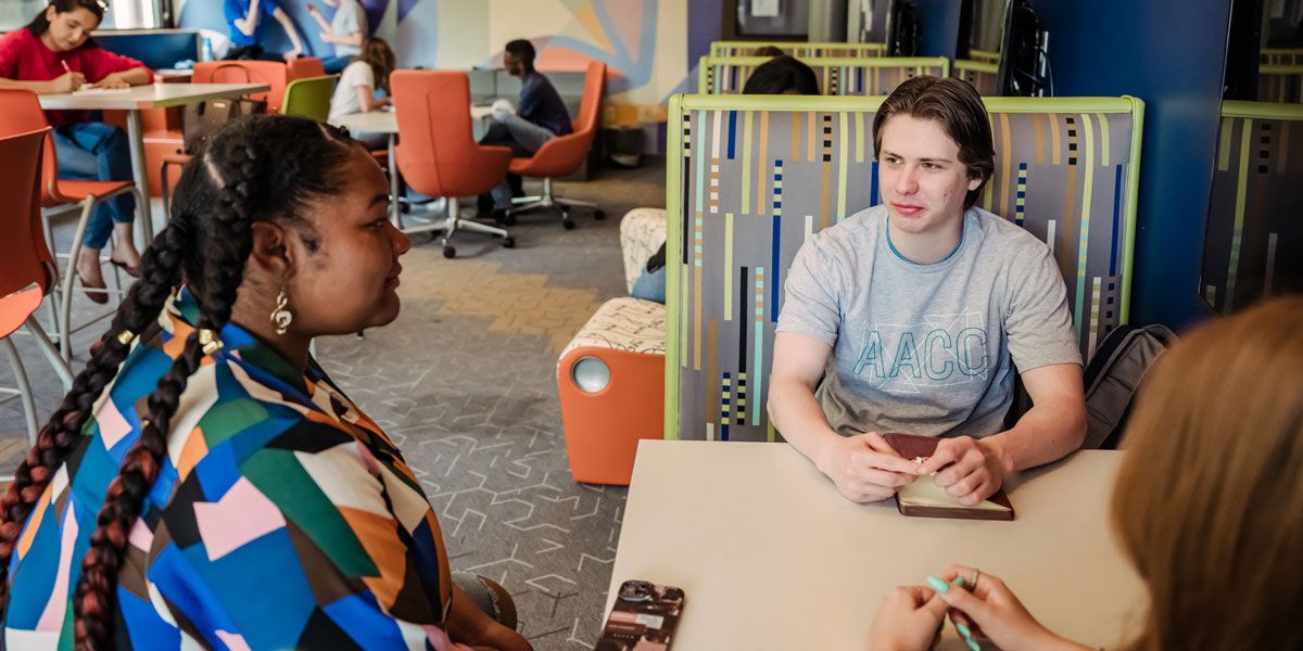 Students sitting around a table talking.