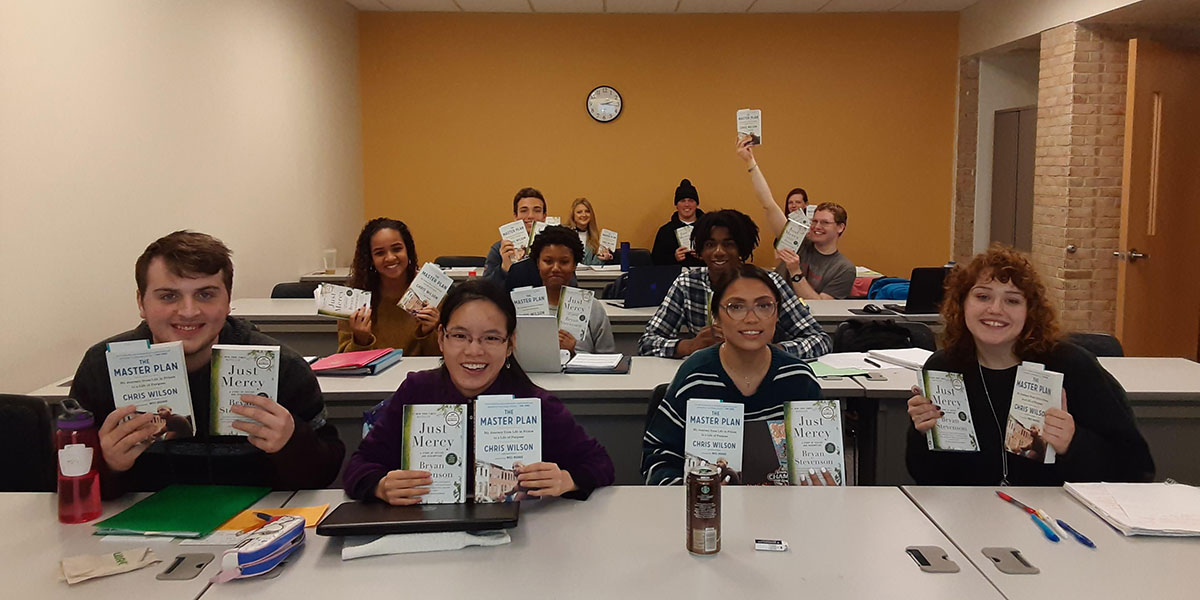 Students in a learning community holding up books